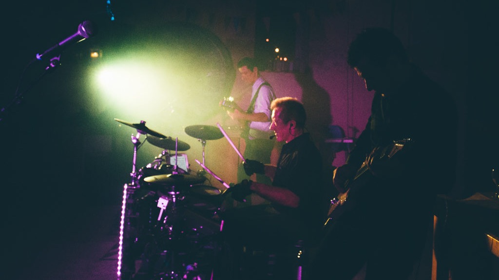 Le groupe FUZZ sur scène en concert, guitare, basse et batterie sous les lumières